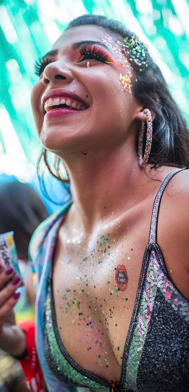mulher sorridente ao participar de ativação da Trident no carnaval de São Paulo fazendo tatuagem instantânea em 3 segundos
